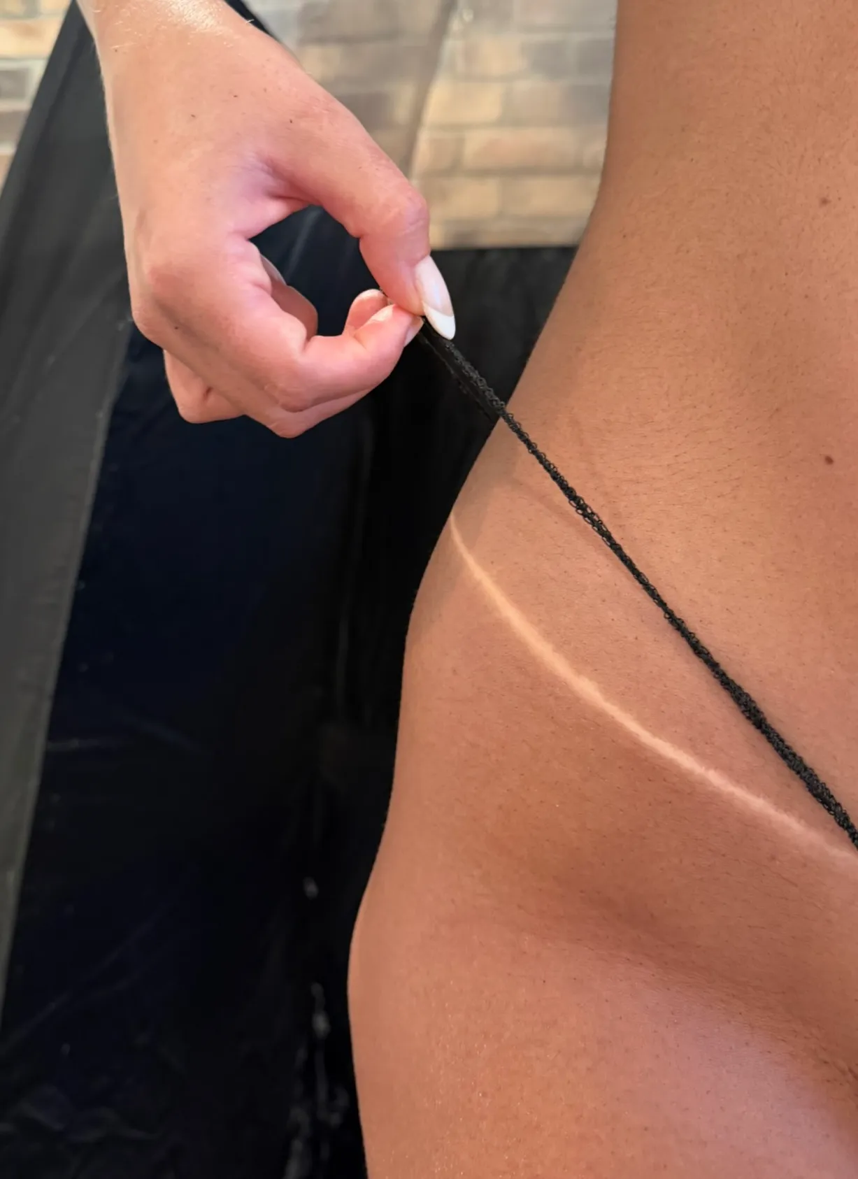 Close-up of a deep, even spray tan with a crisp tan line
